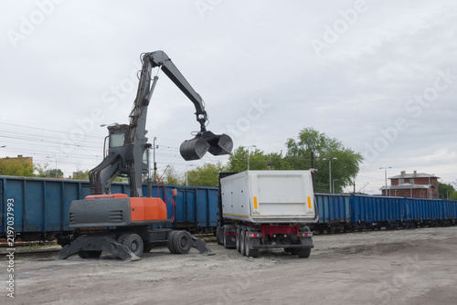 Obraz na płótnie Industrial material handler loading coal from train wagon to truck