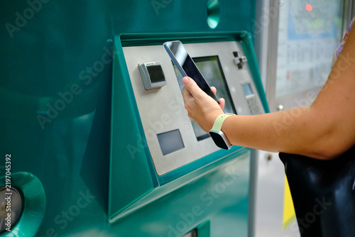 Fotografie Woman paying for public transport using smartphone