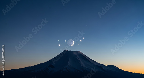 Snowy mountain peak with moon and planets visible in pre-dawn sky above summit