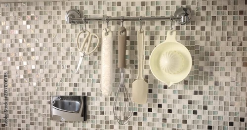 Kitchen rail utensils storage organizer. Modern kitchen interior design ideas. Cozy home cooking domestic routines.