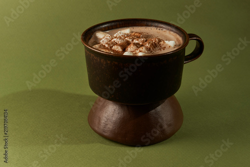 Hot Chocolate with Marshmallows in Dark Mug on Ceramic Stand