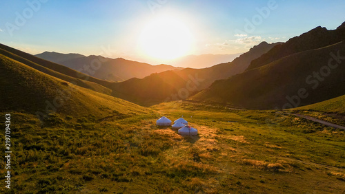 Photography Traditional nomadic yurts in the mountains of Kyrgyzstan at sunset, view from a