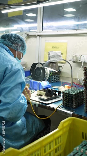 Worker assembling electronics in a manufacturing facility in Noida India