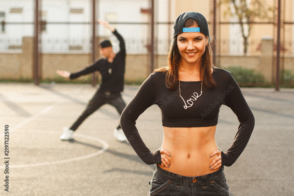 Fototapeta premium Portrait of a beautiful dancer girl on a background of the hip hop dancer.