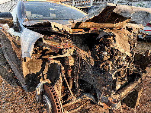 Obraz na płótnie Wrecked car with severe front-end damage, exposed engine compartment, broken bodywork, suspension and wiring after a collision