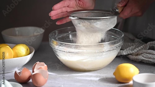 Sifting flour into lemon cake batter, process of home baking