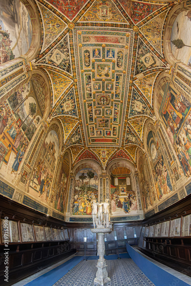 Obraz premium Antique choir books displayed in wooden cabinets in the famous Piccolomini Library, inside the Siena Cathedral (Duomo di Siena) in Tuscany, Italy. Built in the late 15th century (starting in 1492).
