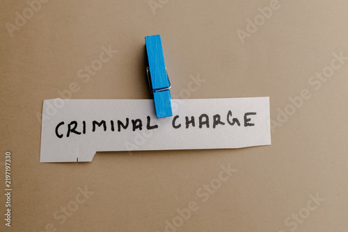 Fotografie A close up view of a white paper strip with the text criminal charge written on