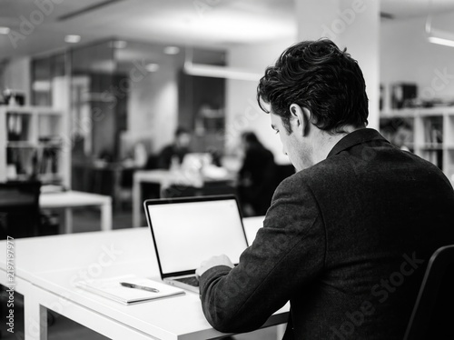 Businessman Working on Laptop in Modern Office Black and White