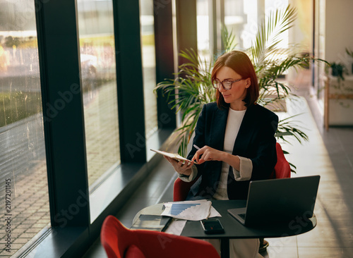 Businesswoman working with a tablet and stylus in a bright office