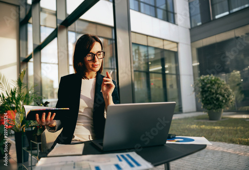 Interior designer with color samples working on a laptop outdoors