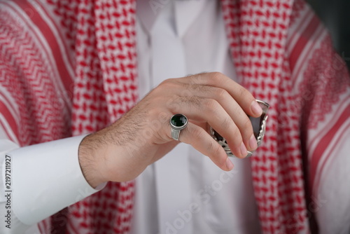 Fotografie Traditional Middle Eastern man in keffiyeh displaying a ring