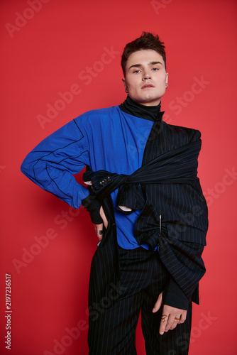 Принти на полотні Young stylish man showcases unique fashion with confidence against a vibrant bac