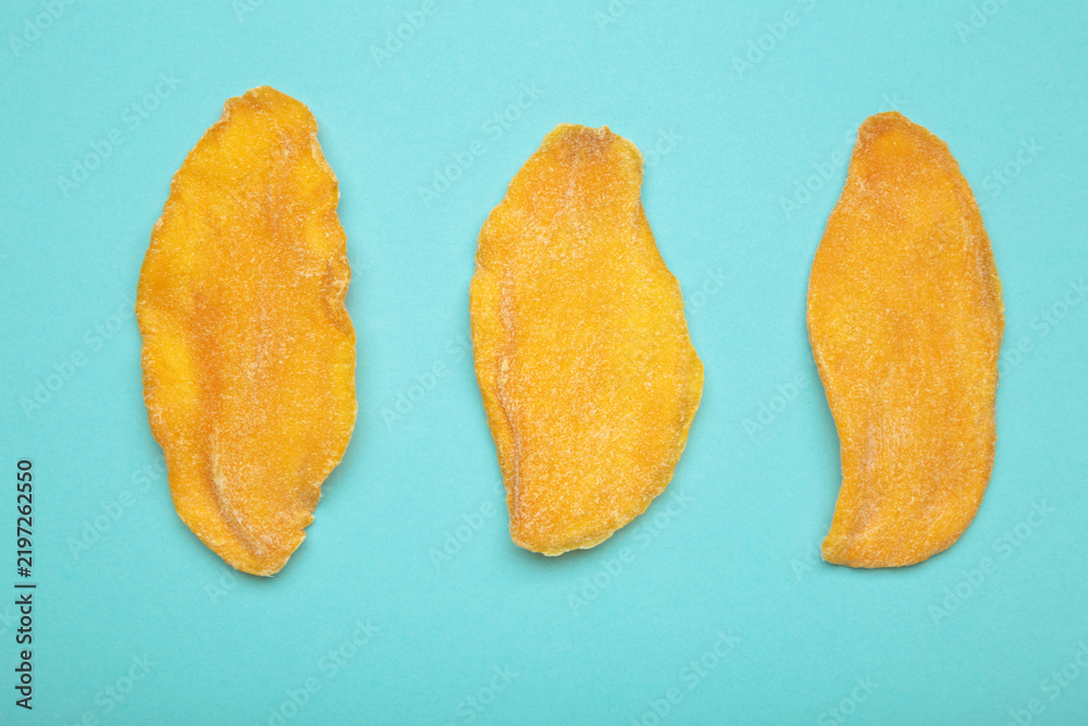 Obraz premium Slices of dried mango on blue background.