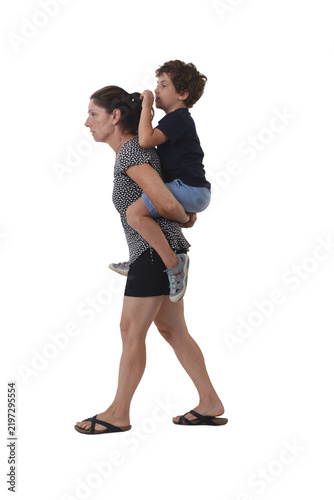 side view a mother walking carrying his son on his back against a white background.