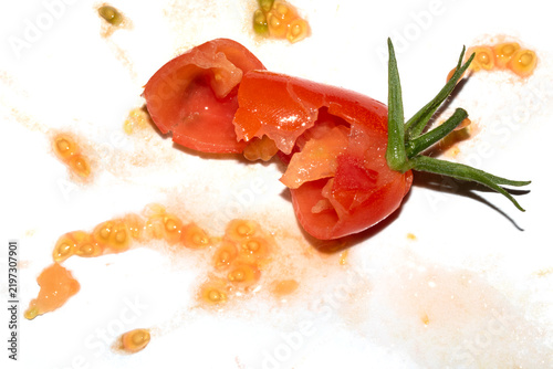 A squashed splattered and crushed broken fresh tomato with seeds