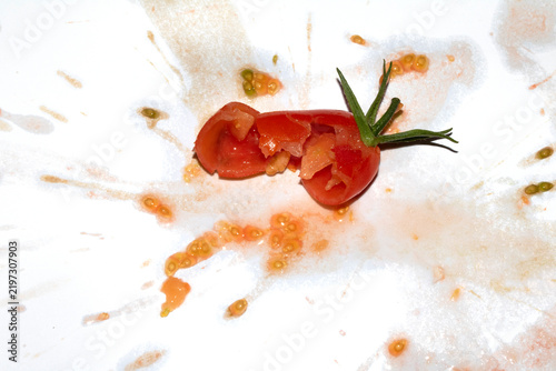 A squashed splattered and crushed broken fresh tomato with seeds