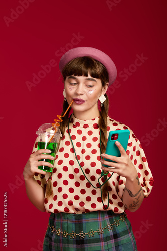Fotografía Cheerful woman expressing vibrant style with colorful outfit and playful drink