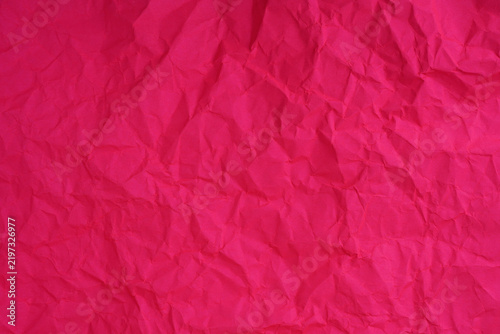 Pink crumpled paper texture with deep wrinkles, folds, and creases creating a textured background