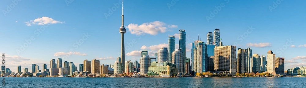 Obraz premium Panoramic View of a Vibrant City Skyline with Tall Buildings and a Prominent Tower Overlooking the Water