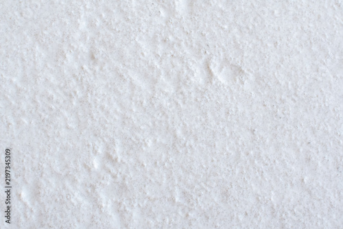 A white, textured porcelain tile surface that creates a subtle abstract background texture