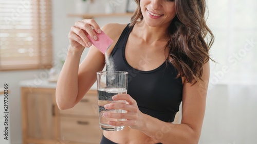 Woman pouring supplement powder into a glass