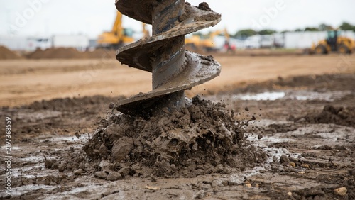 Industrial auger drill digging into muddy ground