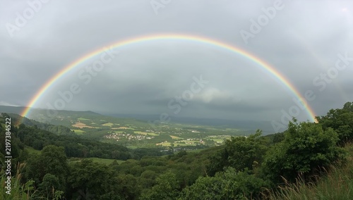 Colorful Rainbow Arches Over a Rural Landscape After a Rain Shower