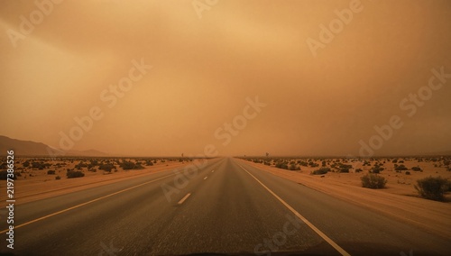 Dust Storm Over a Long Road in a Desert Area During Twilight Hours