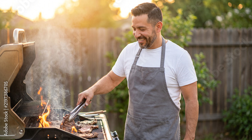 Man grilling carne asada steak on a backyard barbecue at golden hour