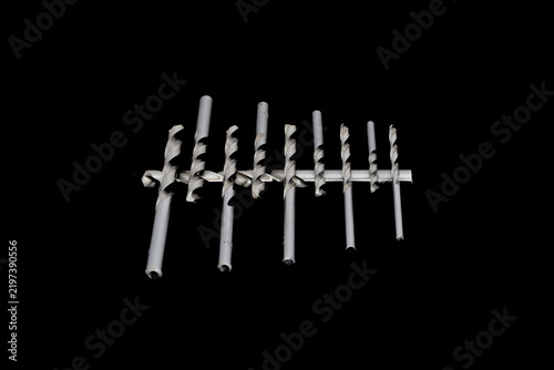 Ultra high-resolution macro photography of a precision twist drill bits set in an organized staggered configuration. 