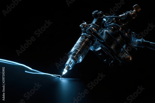 Tattoo machine creating a glowing blue line on a dark background