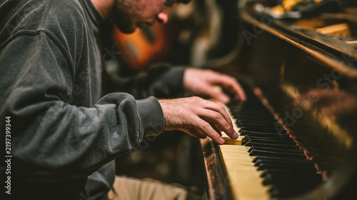 Musician play piano in studio with warm moody lights for concert project
