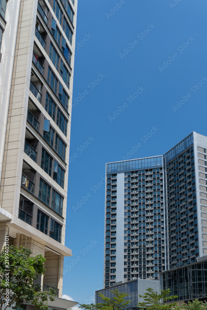 Fototapeta premium Tall office buildings under clear blue sky