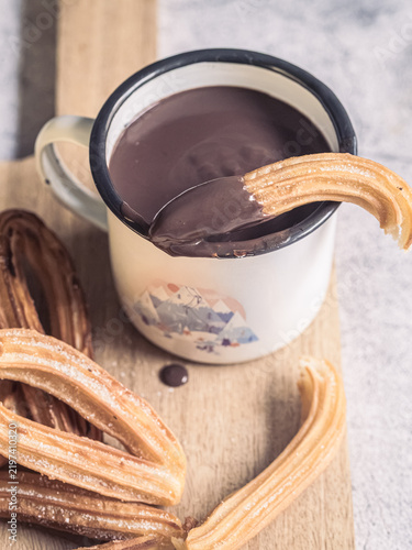 Traditional Spanish churros dipped in hot chocolate, top view