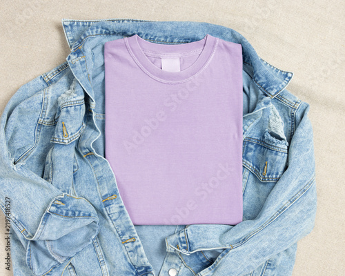 Blank light purple folded shirt mockup over blue denim jacket, crewneck template for print on demand