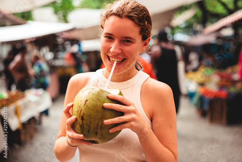Woman Smiling and Drinking Coconut Water at Street Market in Rio de Janeiro