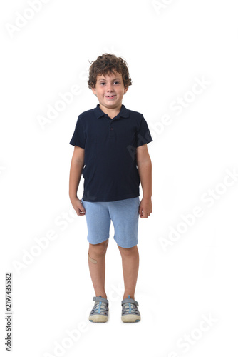 front view of a boy dressed in summer clothes smiling and looking at camera on white background (6 year old)