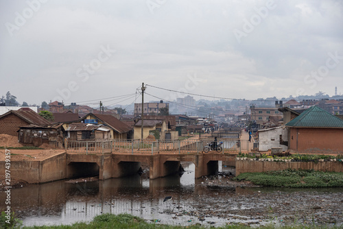 Street scene in Kampala, Uganda with slums and dirty water running through the city.