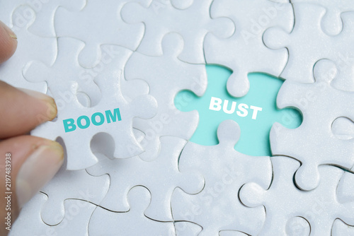 Foto Piece of jigsaw puzzle boom bust phrase.