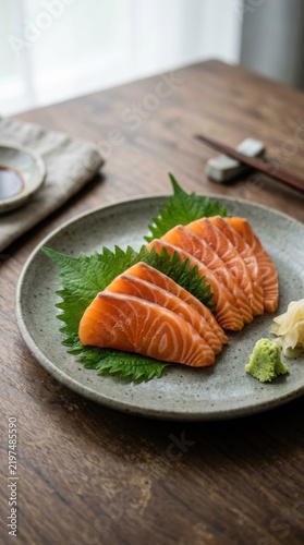 Neatly sliced salmon sashimi on ceramic plate with shiso and wasabi
