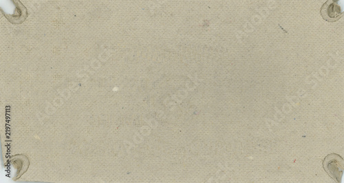 Gray cardboard with frayed corners, showing signs of wear. The surface is textured with faint speckles of various colors. Corners have circular holes, indicating previous attachment points.