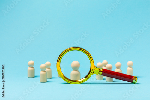 Magnifying Glass searching among people icons on background. Recruitment, talent search, human resources, employee selection, leadership, hiring, team management, business analysis concept.