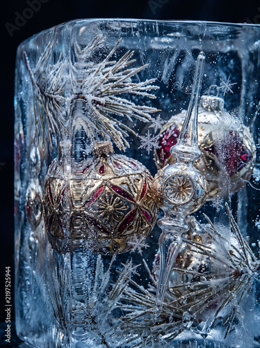 Macro photography of exquisite Christmas ornaments frozen inside transparent ice, delicate snowflakes and pine needles trapped within the ice 