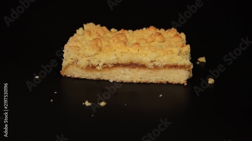 Chef Hands Lifting Fresh Apple Crumble Cake Slice from Black Background
