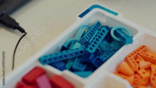 Multi-colored construction toy bricks sorted in organizer box, STEM education concept