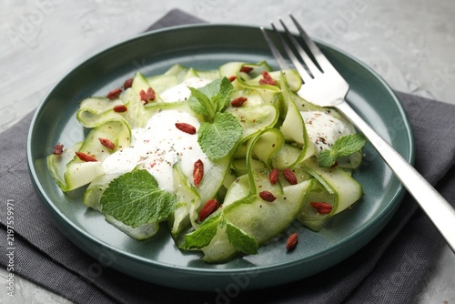 Obraz na płótnie Tasty salad with cucumber slices, goji berries and mint served on grey table, cl