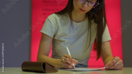 Young female student signing an important document