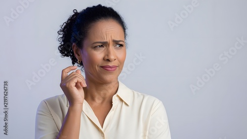 Person with a skeptical facial expression and a questioning gaze conveying doubt and suspicion in an expressive portrait highlighting disbelief and critical evaluation through nonverbal communication.