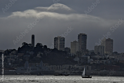 Thick Fog bank heads for San Francisco skyline with sailboat heading back to marina before visibility diminishes